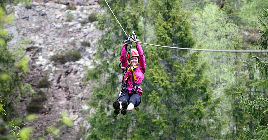 Kvinde har det sjovt på zipline i smålånd på sin efterårsferie i Sydsverige