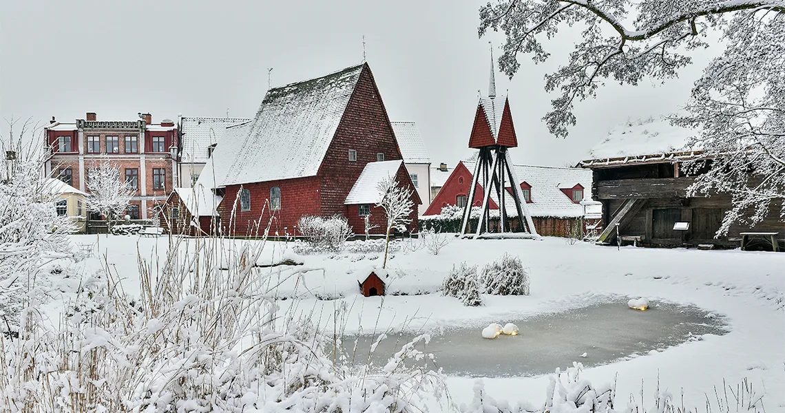 Den gamle Bosebo Kirke hos Kulturen i Lund en smuk vinterdag klædt i sne. Her ses den gamle kirke og den frosne sø foran.