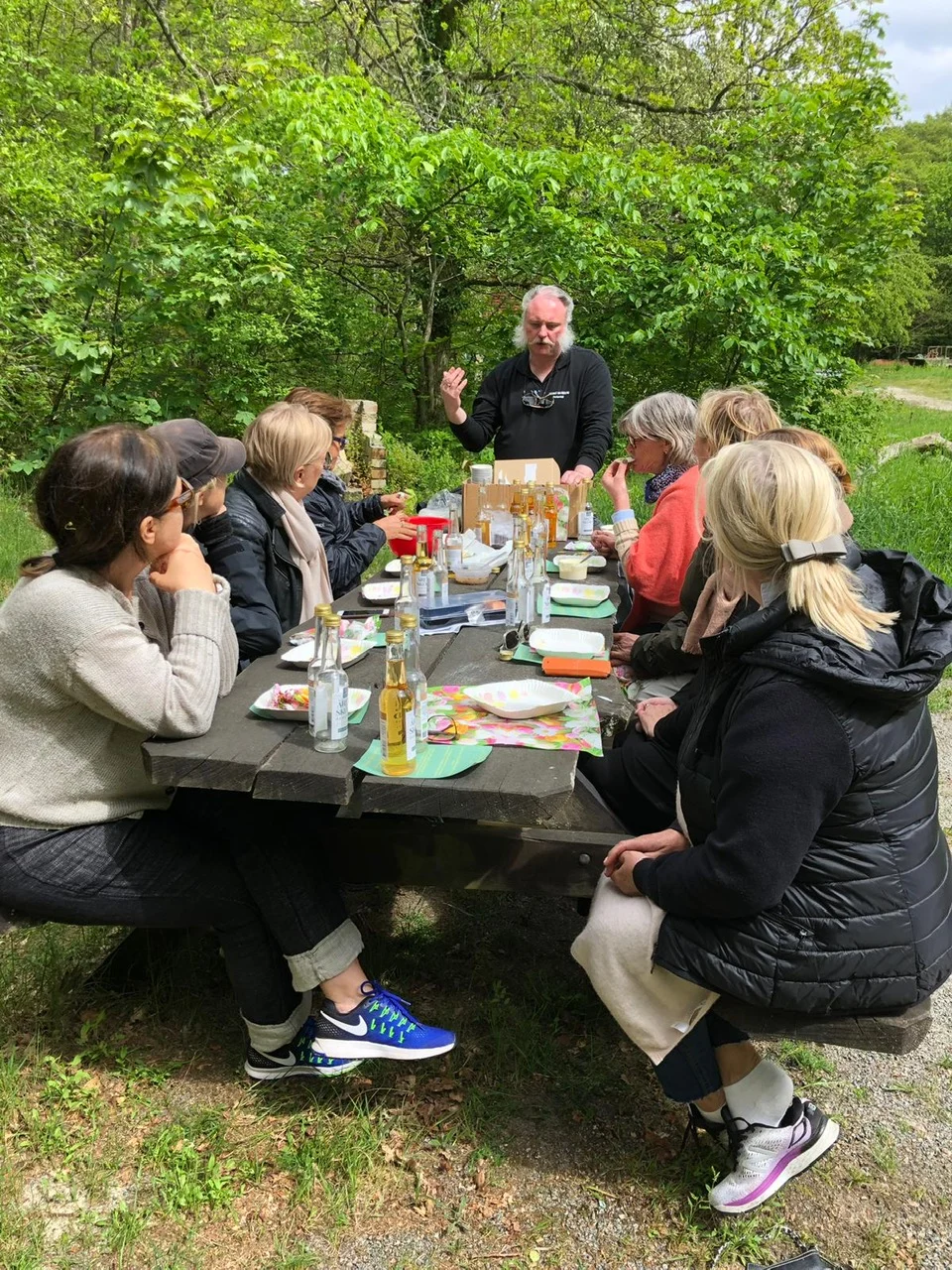 Vandring på Kivik: Gæsterne på turen smager på Kivik ved et bord.