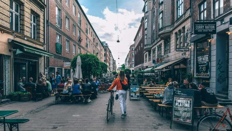 Kvinna gå med cykel på Blågaardsgade på Nørrebro i Köpenhamn.