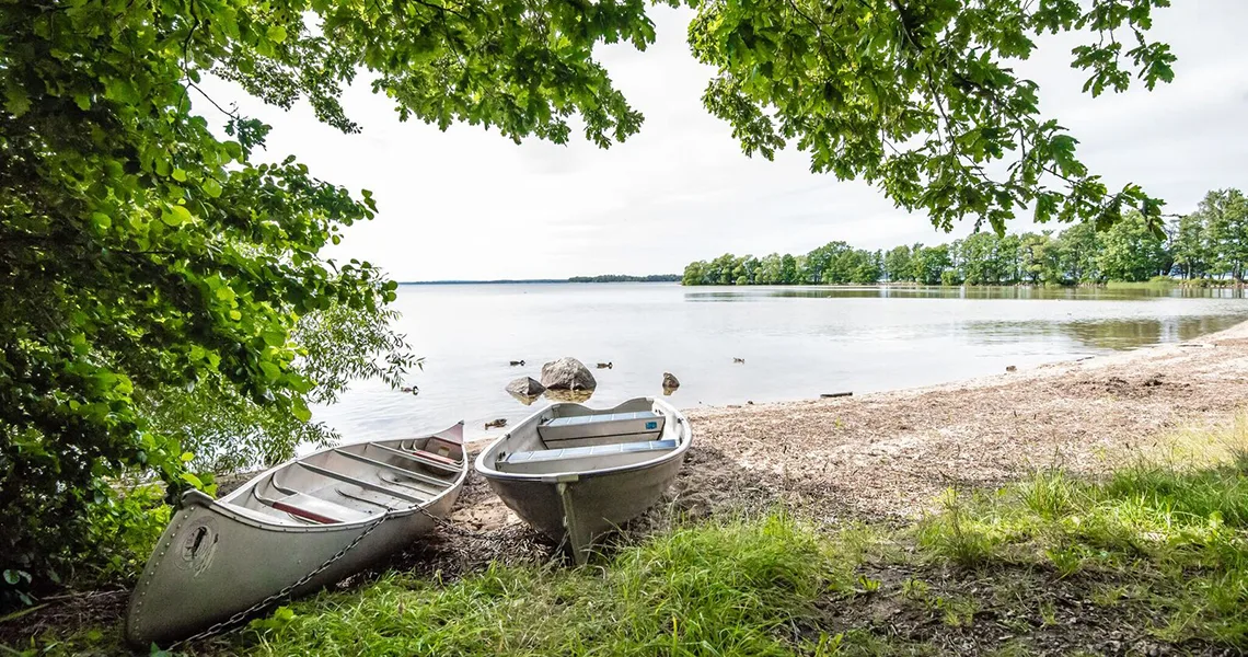 En båd og en kano på bredden af Ivösjön i Skåne.