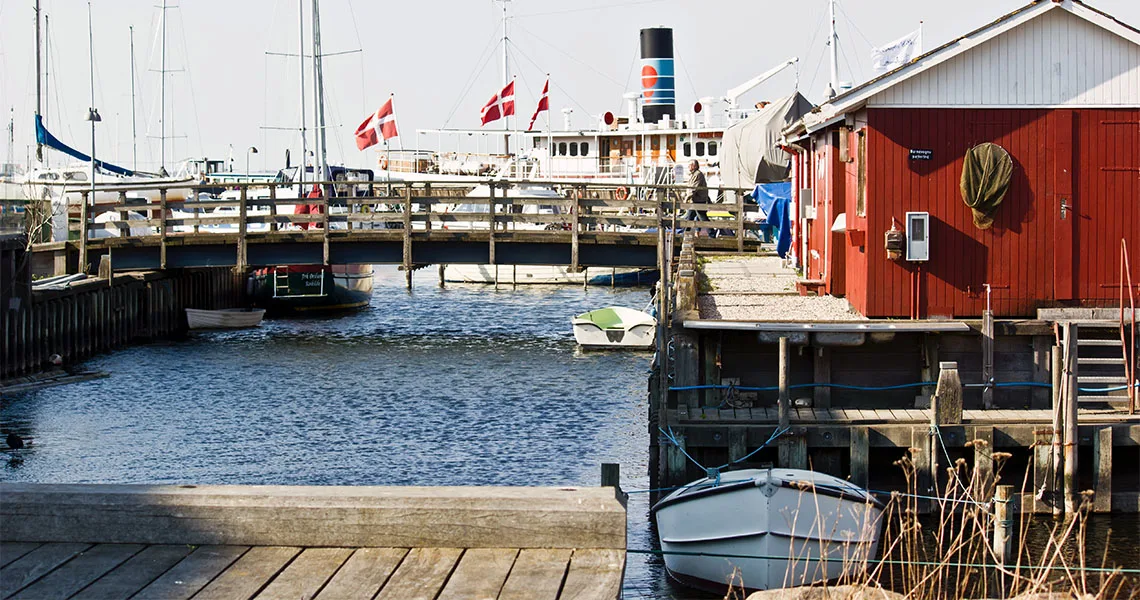 Hamnen i Roskilde med räbryggor, båtar och danska flaggor.