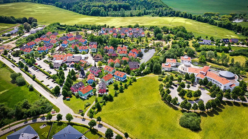 Flygfoto som visar hela området med byggnader, park och genomfartsvägar.