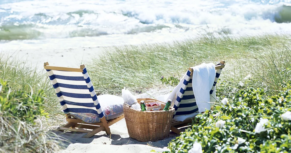 To liggestole og en picnickurv på stranden Sandhammaren i Österlen.