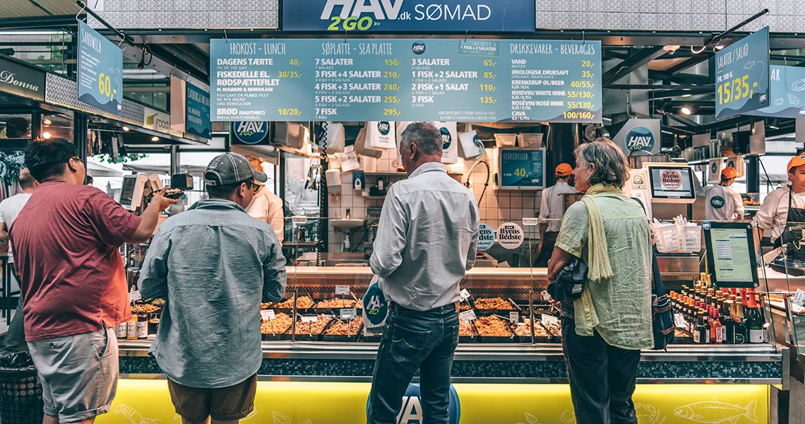 Människor som handlar vid fisk- och skaldjursdisk på Torvehallerne i Köpenhamn.