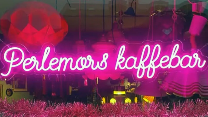 En rosa neonskylt som stavar caféets namn i skyltfönstret.