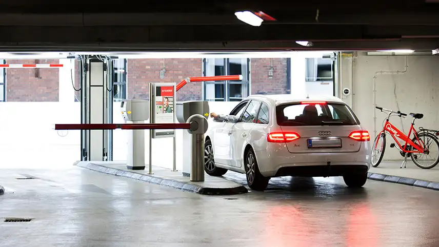 En bil kör ut från ett av Q-Parks parkeringsgarage.