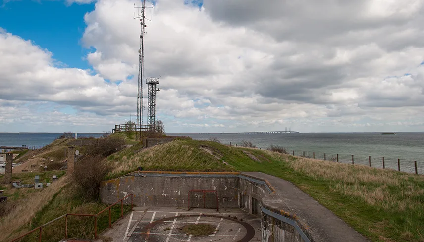 Bild tagen uppe på Dragør Fort. Man ser gamla radioantenner, toppen på en underjordisk bunker och grönt gräs mot det blå havet.
