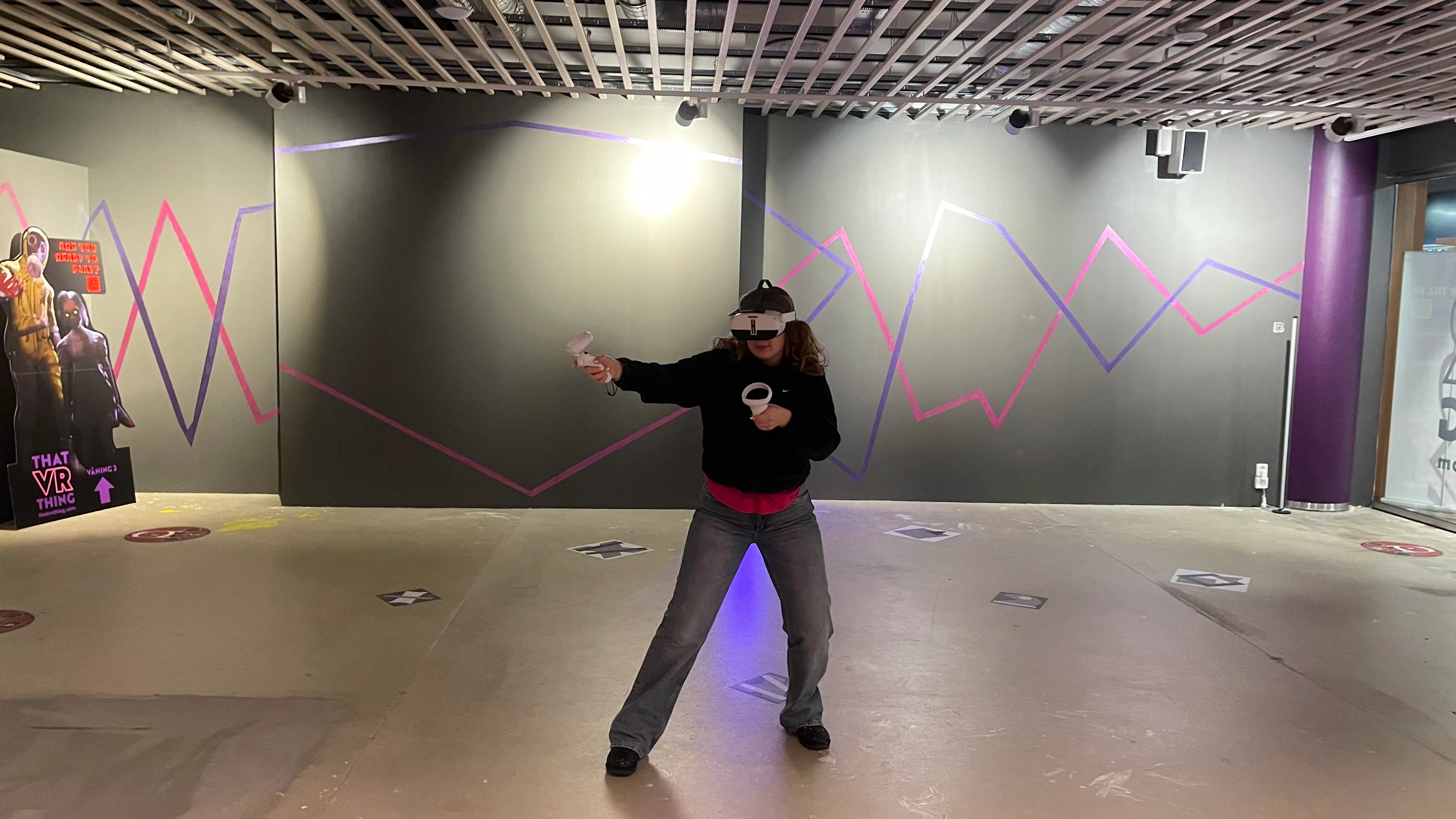 En person spiller et Virtual Reality spil hos That VR Thing i Malmø med VR-briller og udstyr.