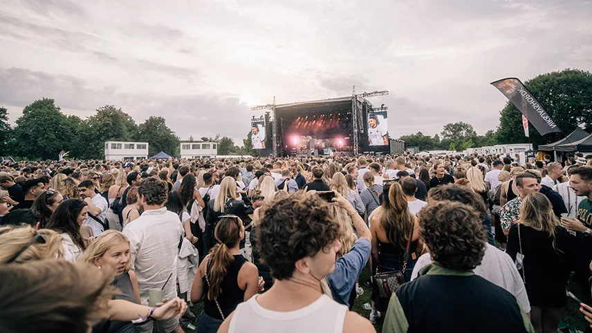 Bild av scenen på avstånd. Man ser publik som står och väntar på att en konsert ska börja.