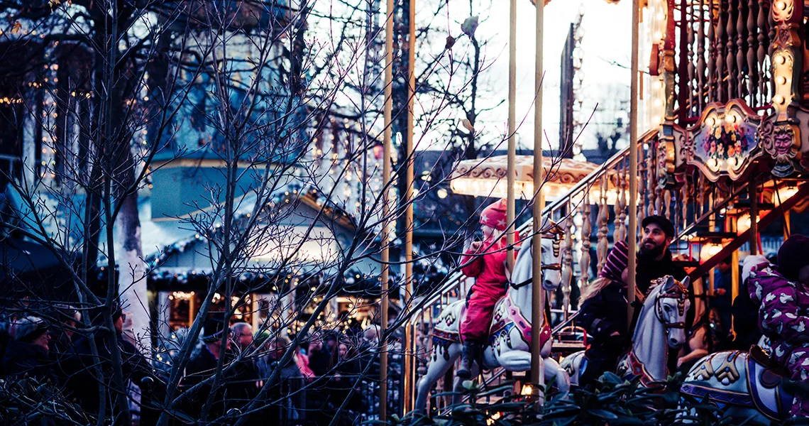 Barn åker karusell med hästar på Tivoli i Köpenhamn.