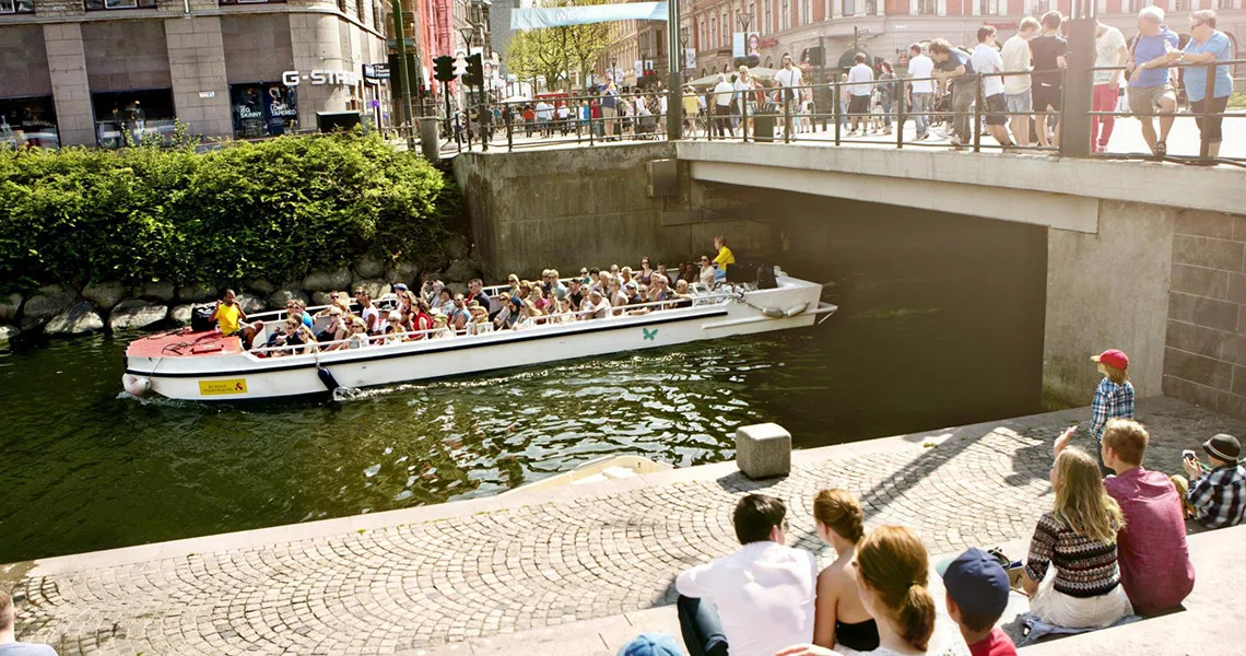 Sightseeingbåd med mennesker i kanalen i Malmø.