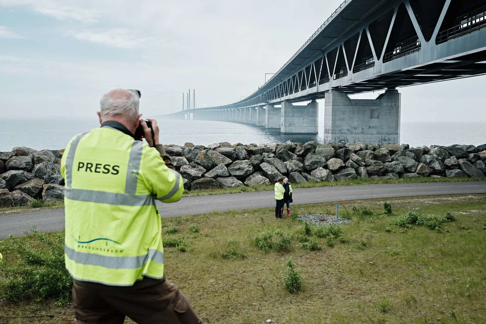 Press photographer in front of bridge