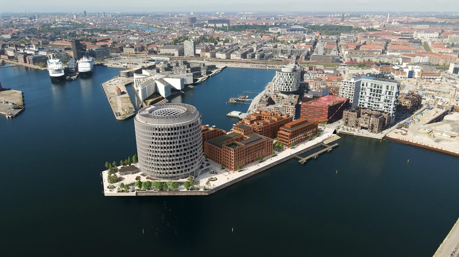 Flygfoto över hamnområdet med moderna byggnader och färjor, som inkluderar Fairfield Hotel vid vattnet