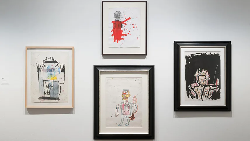 En vit vägg med fyra inramade teckningar av Jean-Michel Basquiat.