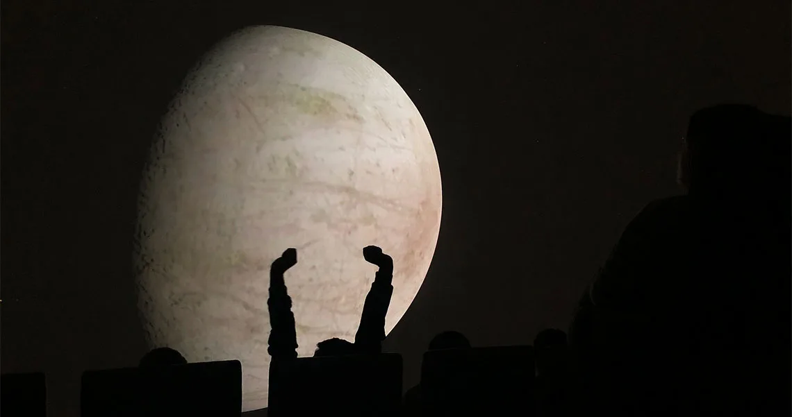 Armar som sträcks ut framför planet på Planetarium i Köpenhamn. 