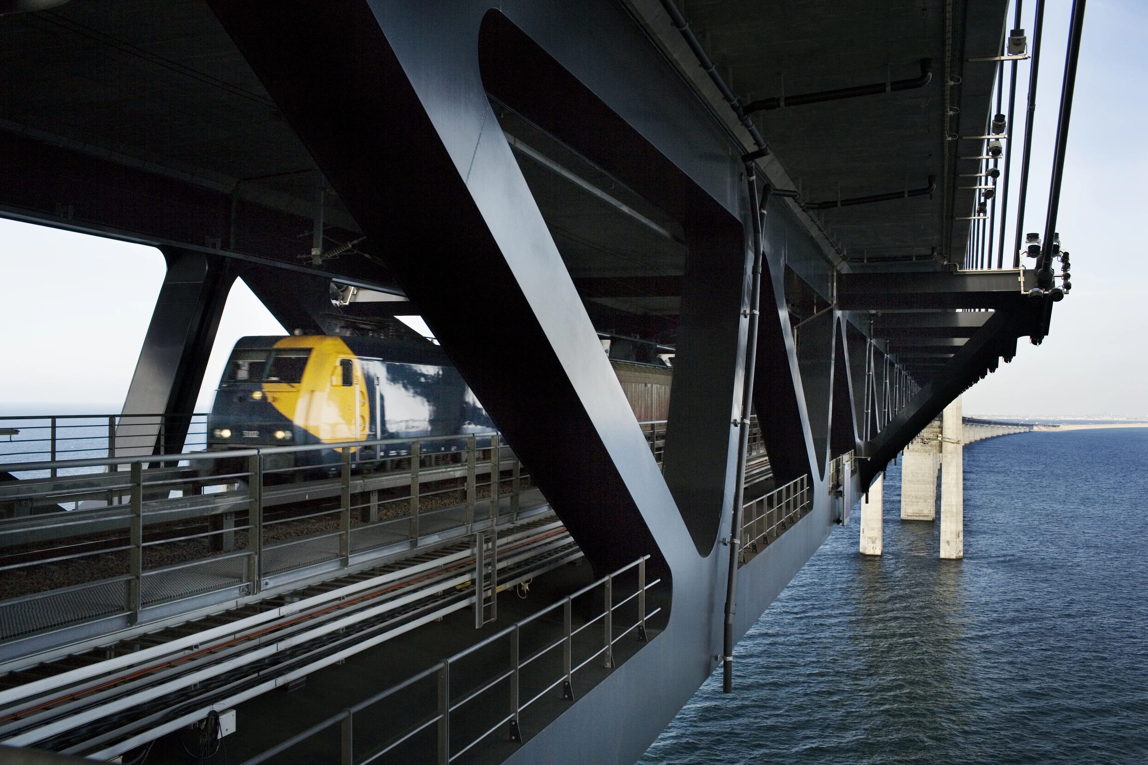 Train rush past on railway track under the Øresund bridge