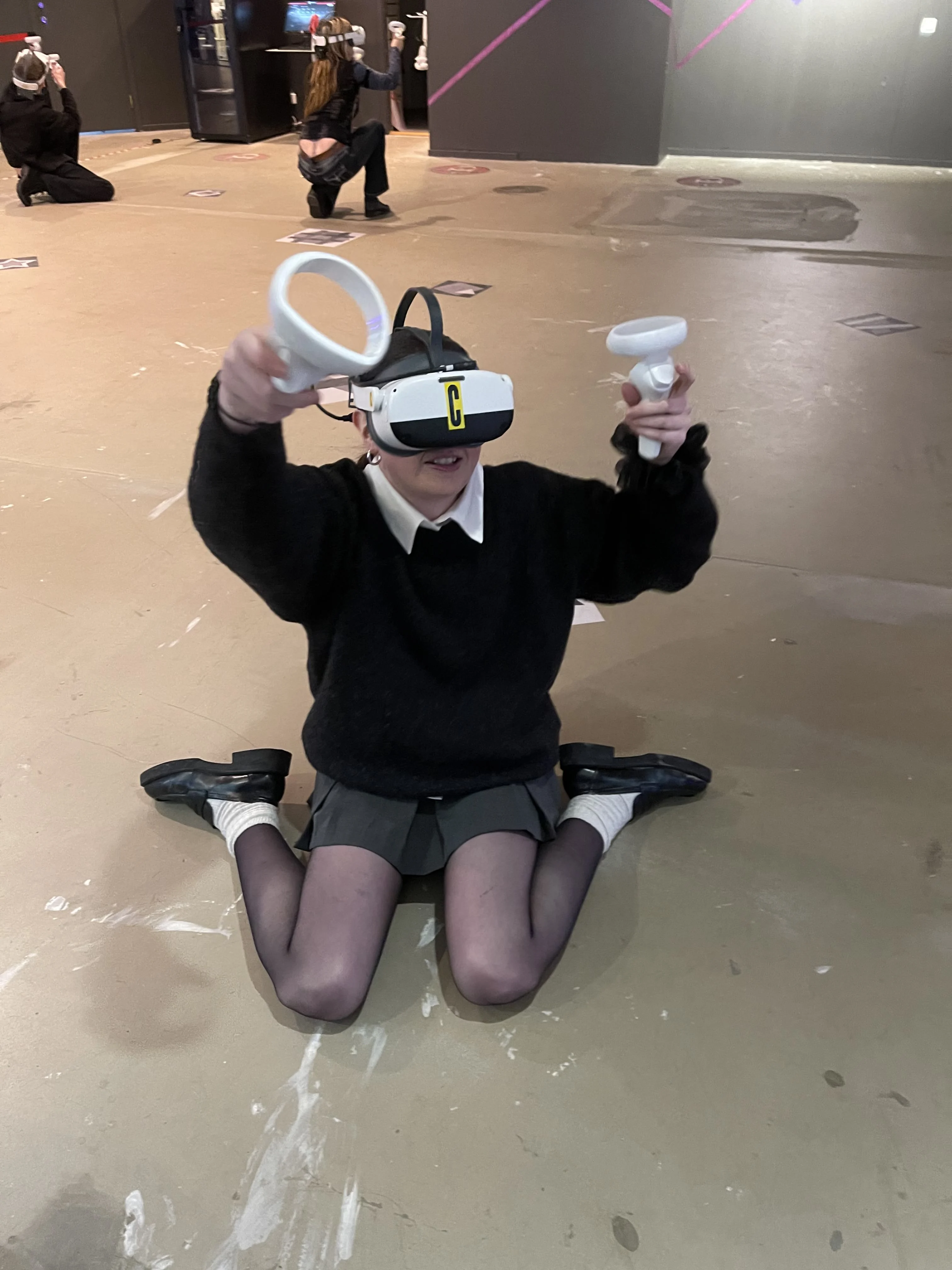 Pige spiller Virtual Reality-spil hos That VR Thing i Malmø med både VR-briller og VR-håndtag.