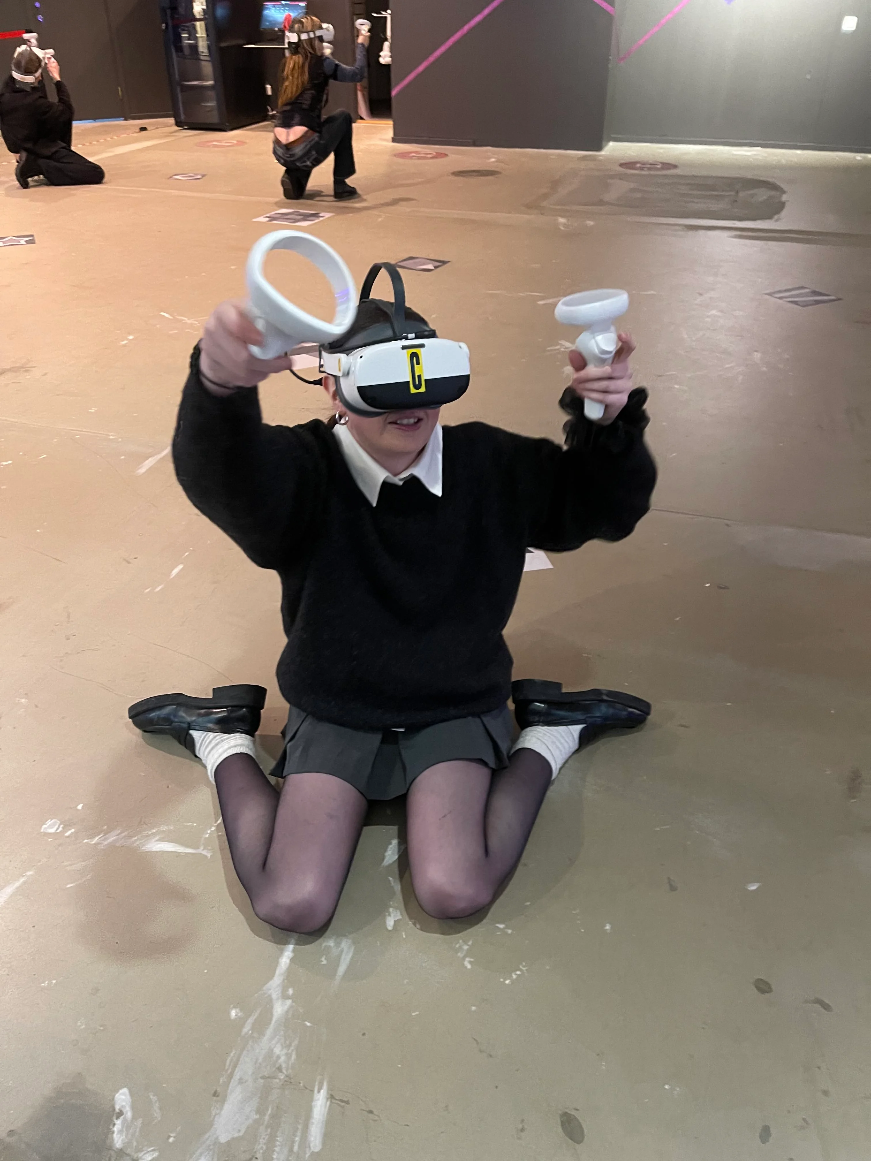 Pige spiller Virtual Reality-spil hos That VR Thing i Malmø med både VR-briller og VR-håndtag.