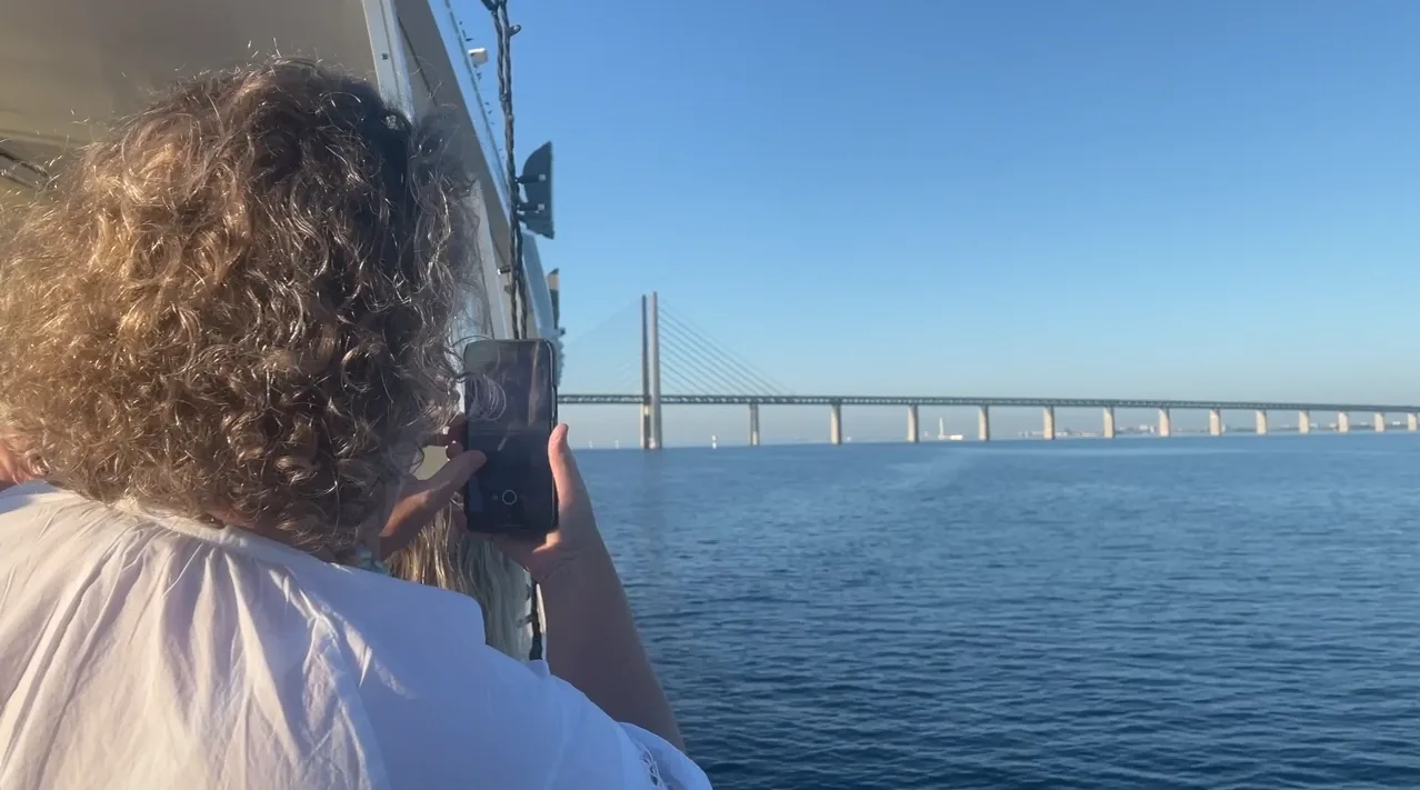 Bro-Safari på MS Tilda och en gäst fotograferar Øresundsbron från båten.