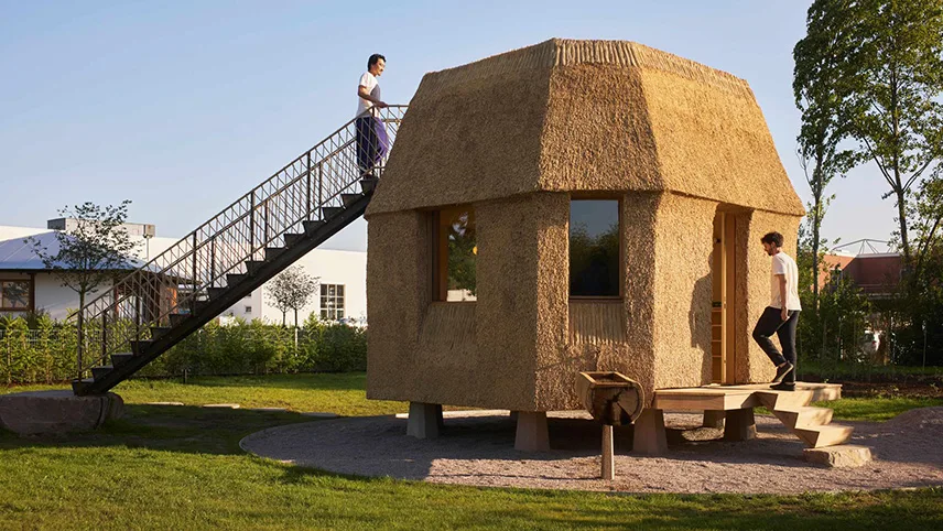 Ett hus byggt av ATTA – Atelier Tsuyoshi Tane Architects med inspiration från historisk arkitektur. Två besökare syns på verandan.