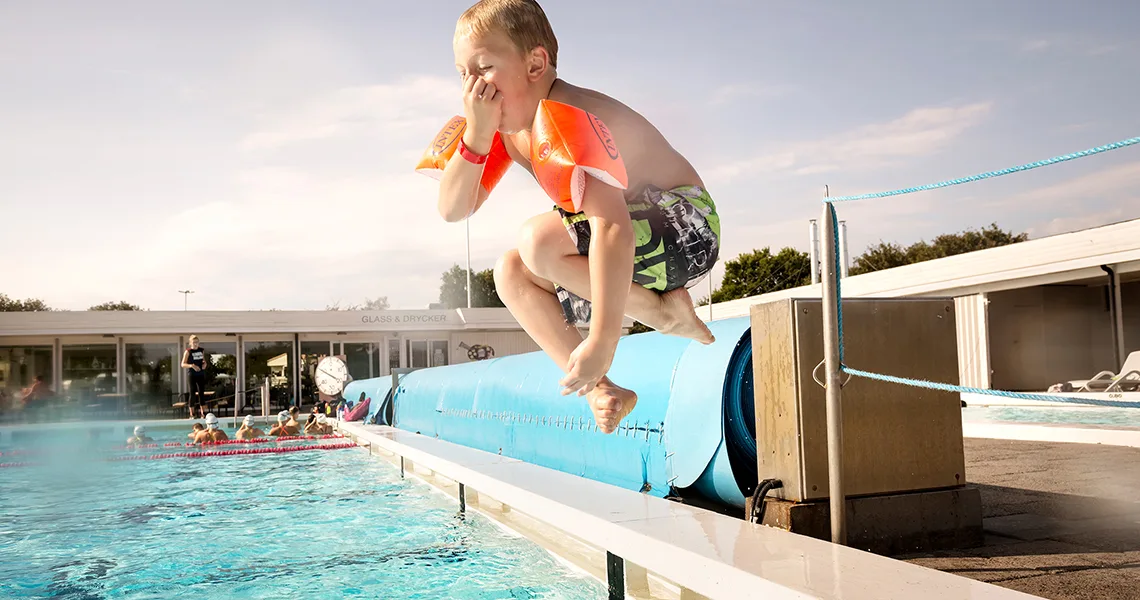 Dreng i pool på campingferie i Sverige.