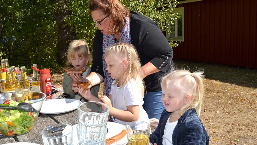 Tre børn og en voksen spiser pølser på Destination Snogeholm.