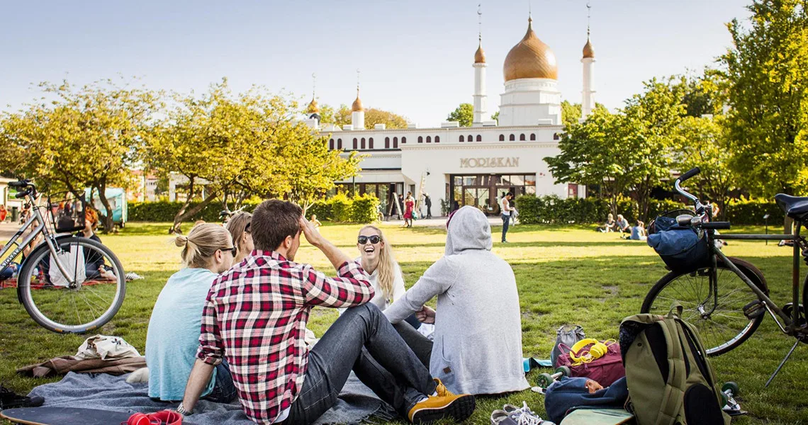 Mennesker på picnic i græsset i Folkets Park i Malmø.