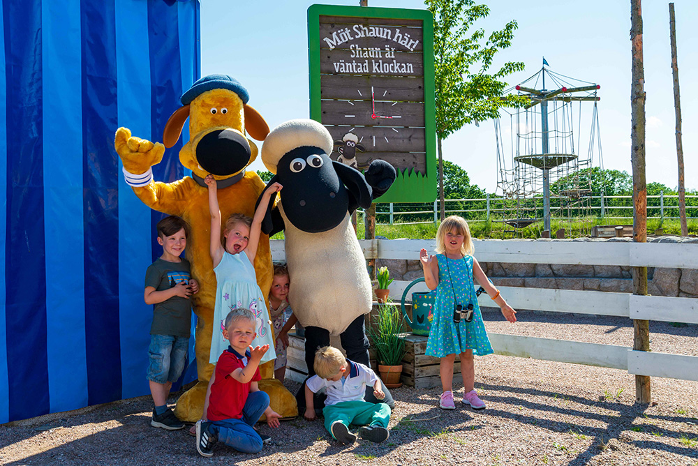 Påske i Skånes Djurpark - en flok børn står sammen med figurerne fra parken og solen skinner.