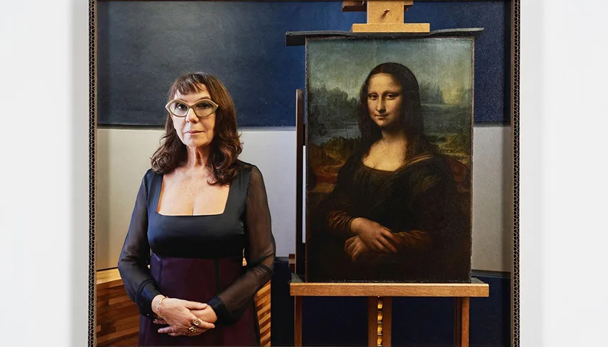Fotografi av konstnären Sophie Calles som står står bredvid den berömda tavlan Mona Lisa. Konstnären är klädd i liknande kläder och poserar precis som Mona Lisa.