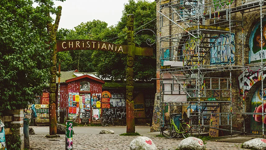 Ingången till fristaden Christiania, omgiven av grönskande träd.
