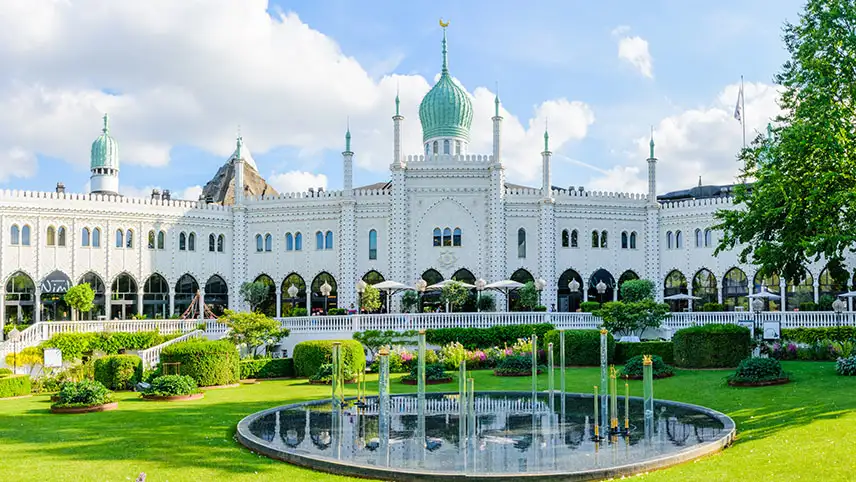 Tivoli-palatset med gräsmatta, park och fontäner i förgrunden.