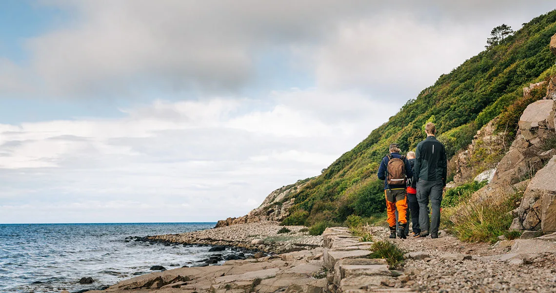 Tre personer på vandretur ud til havet i Kullaberg Naturreservat