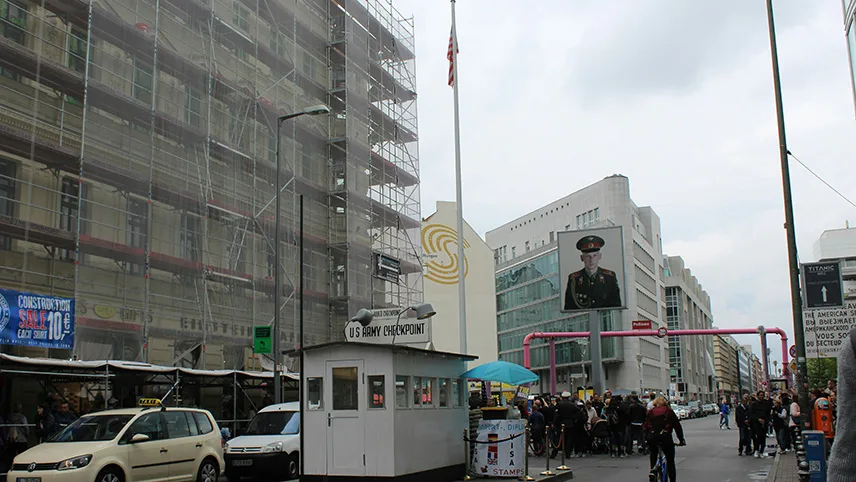 Checkpoint Charlie med den vita militärkuren, skylten och flaggan.