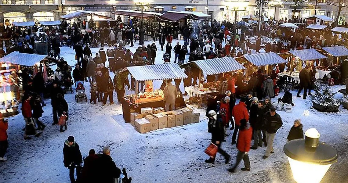 Julemarkedet i Kristianstad set fra oven med markedsboder, besøgende og julelys.