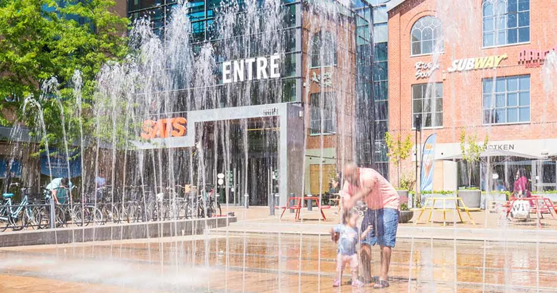 Indgangen til shoppingcentret Mobilia med et springvand foran.