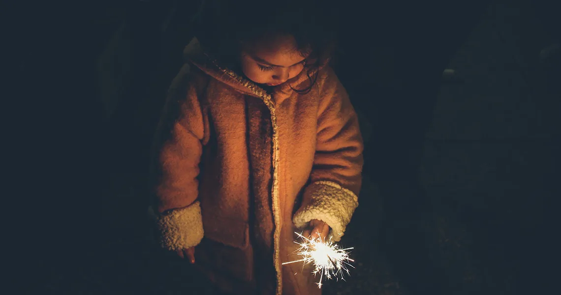 Barn med tomtebloss på julmarknad i Danmark.