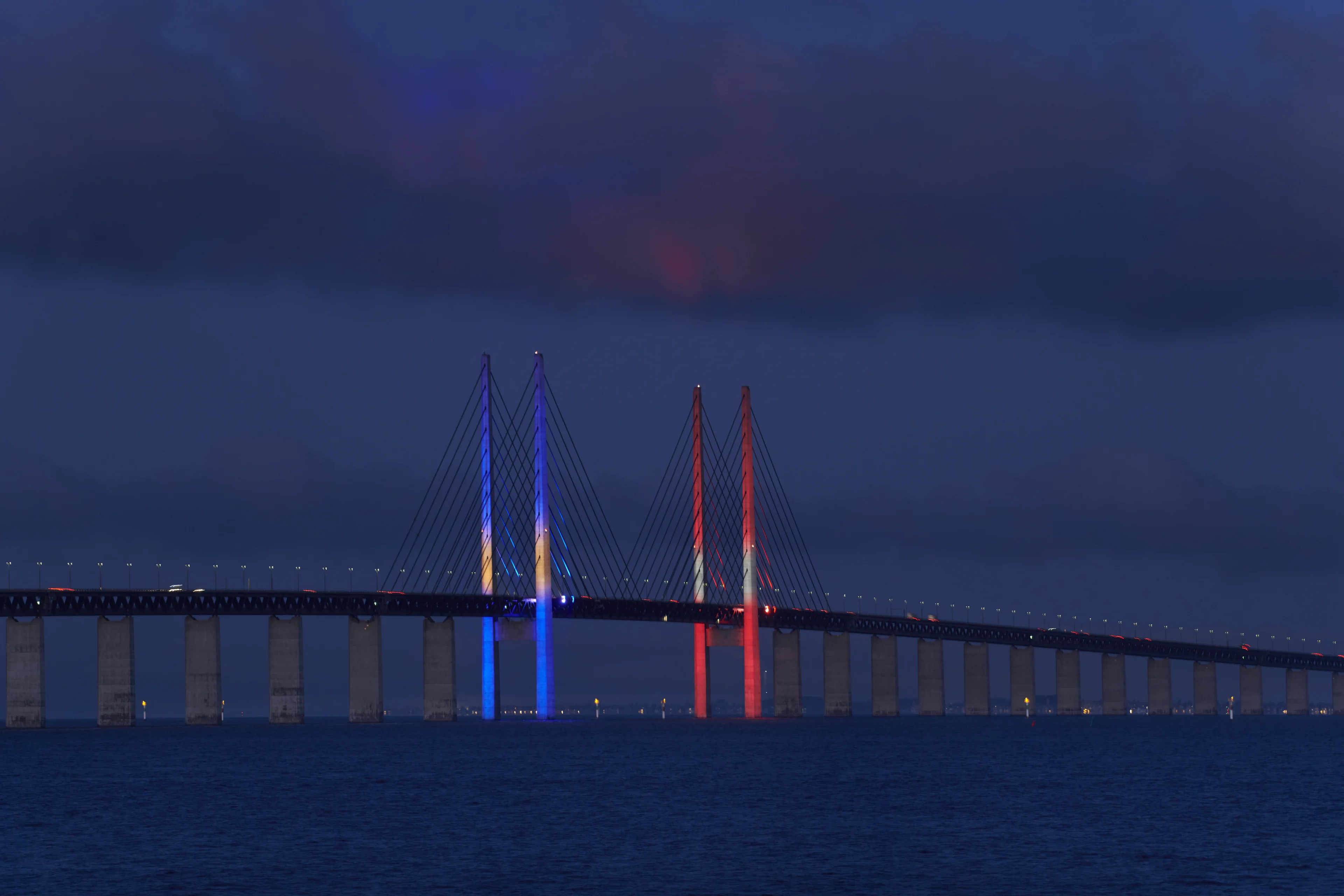 Øresundsbrons  pylonbelysning i farverne fra det svenske og danske flag - blå, gul, rød og hvid.