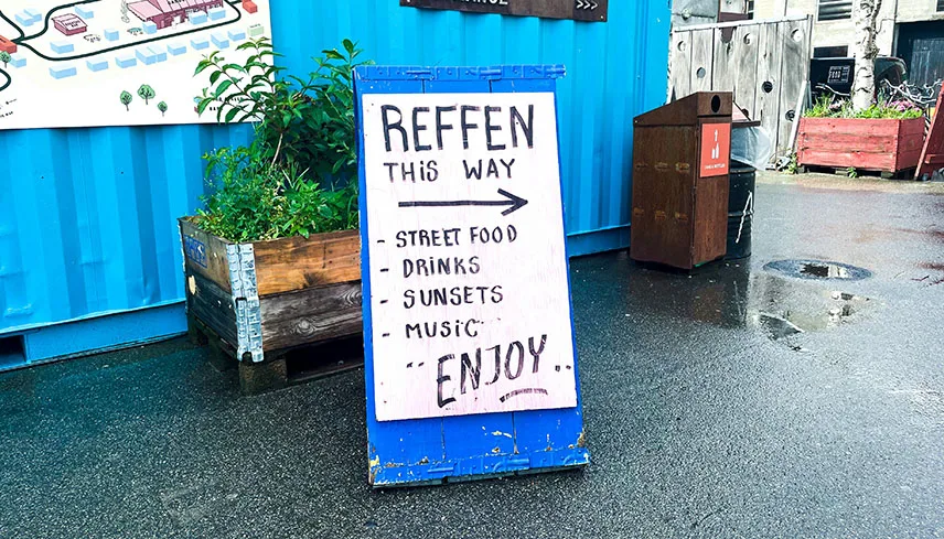 En blå container och en skylt om Reffen street food.
