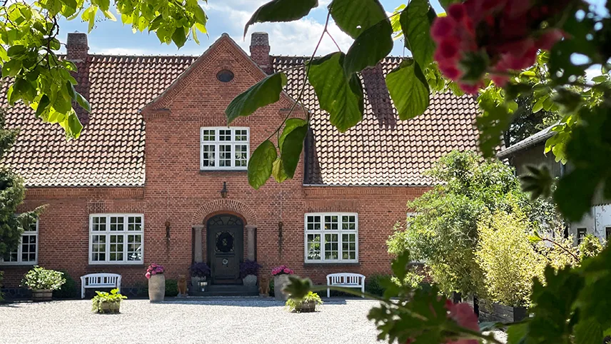 Gårdsplan och fasad på The Norrmans Farmhouse sett från infarten.