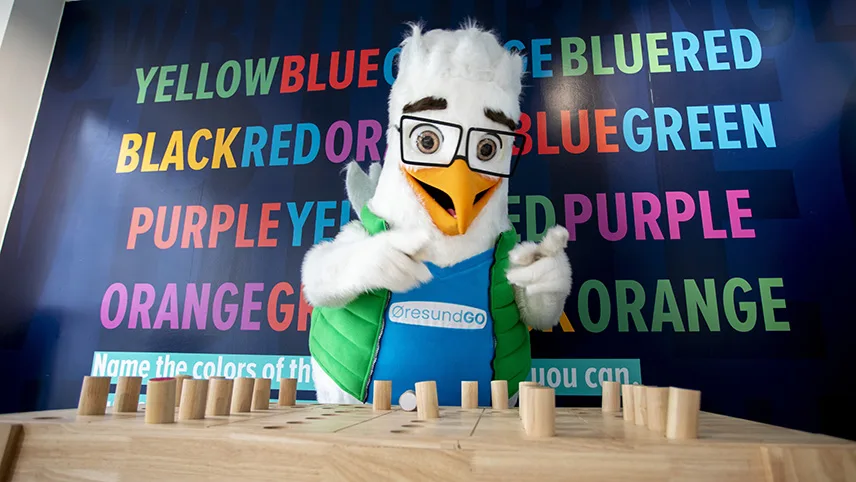 Gustav står i en interaktiv monter och pekar på bordet.