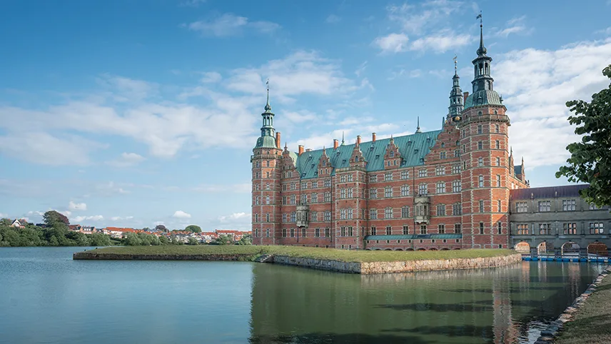 Frederiksborg slott med vatten framför.
