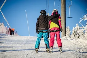 To børn er på vej op ad skibakken ved Mösseberg og Falköping via en lift.