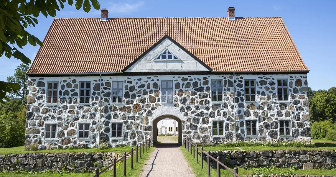 Stort hus med öppet valv som är ingången till Hovdala slott.