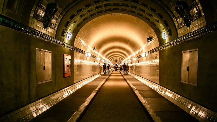 Fotgängare inne i den upplysta St. Pauli Elbtunnel.