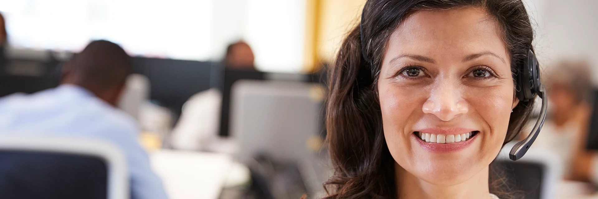 Leende kvinna med headset som arbetar inom kundservice