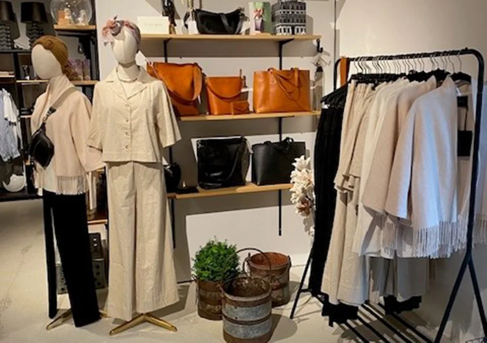 Tøj på mannequiner i Bottega stile i Lund og tasker i baggrunden.