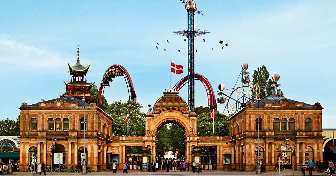Stora ingången till Tivoli i Köpenhamn med karuseller i bakgrunden. 
