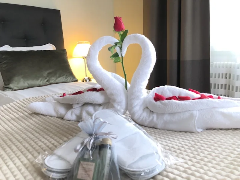 Palm Tree Hotel i Telleborg. Her ses et af deres fine værelser, hvor de har anrettet håndklæder romantisk med rosenblade som to svaner.