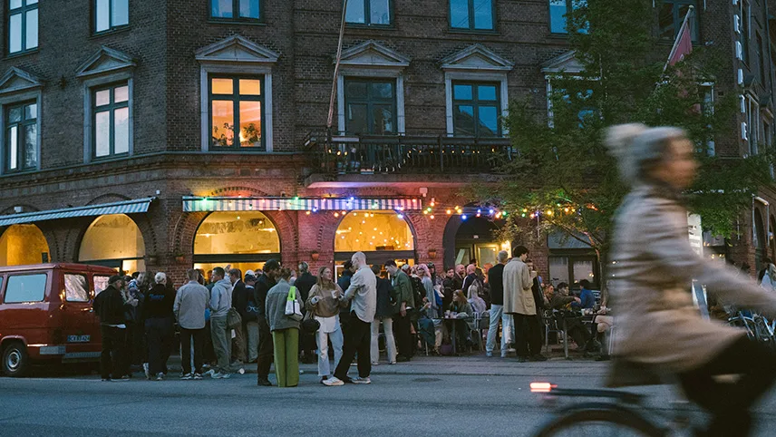Människor som står på gatan utanför en mysig restaurang i Köpenhamn. 